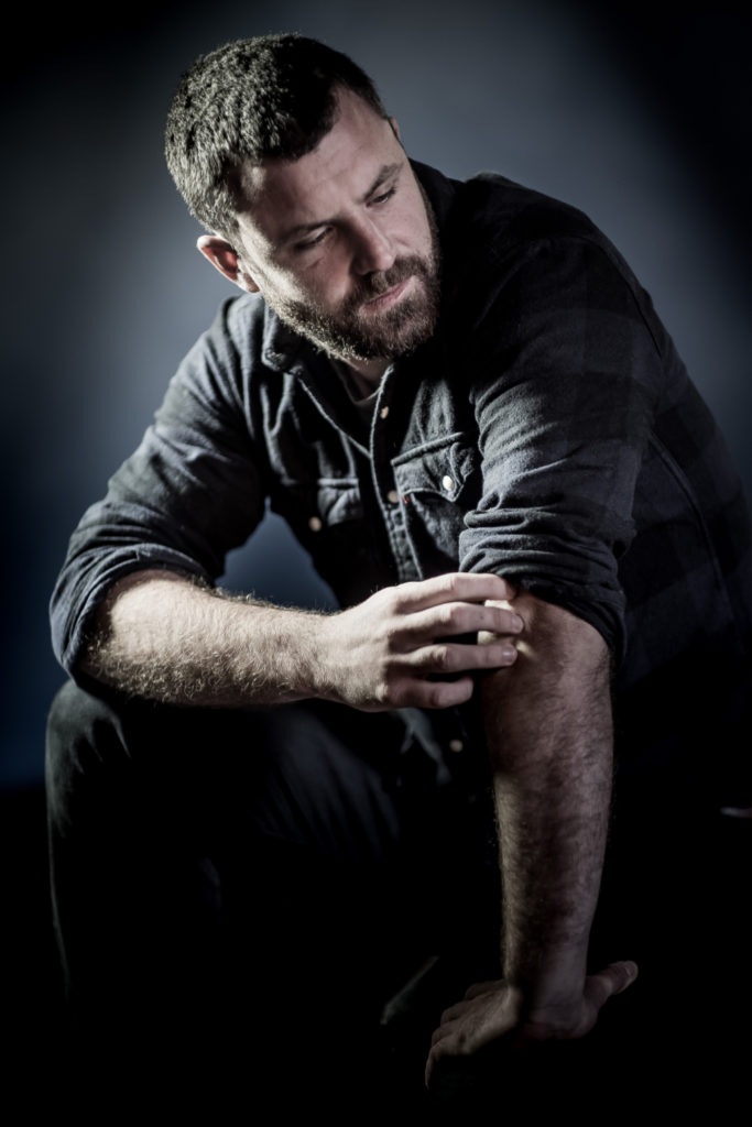 Man sitting down, leaning on knee
