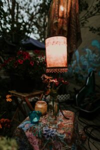 Flower in vase with aged lit lamp on outdoor table
